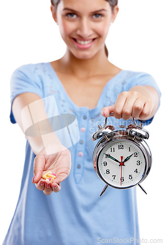 Image of Pills, clock and portrait of a woman in a studio waiting to take medicine, vitamins or supplements. Tablets, health and female model with alarm as a medication reminder isolated by white background.