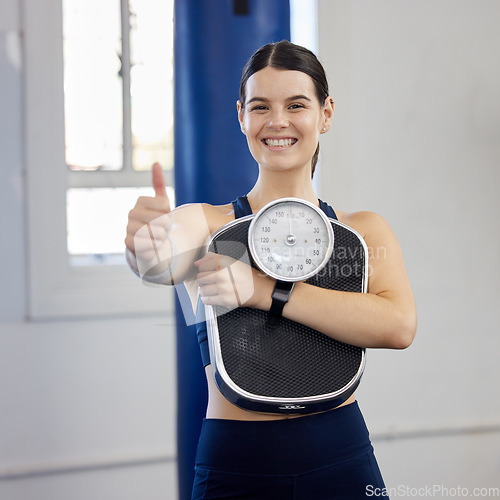 Image of Woman, gym portrait and thumbs up with scale, wellness and weight loss goal for health, body or fitness. Girl, healthy and workout to lose weight, exercise or focus on anatomy, self care or happiness