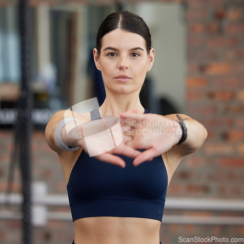 Image of Fitness, athlete and woman doing a stretching exercise before an intense workout in gym. Sports, training and portrait of girl doing warm up workout for wellness, health and strength in sport center.