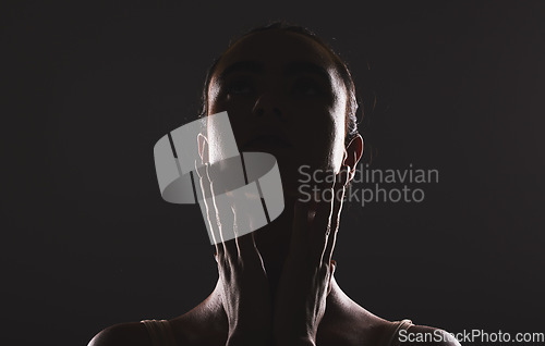 Image of Woman, beauty and face silhouette in dark fantasy, cosmetics and dream aesthetics. Shadow, black background and model headshot while touching facial skin in mystery, studio background and erotic body