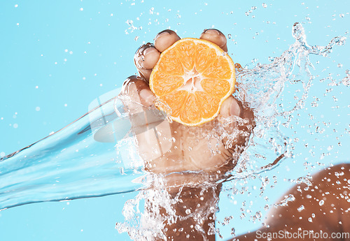 Image of Water splash, orange in hand and studio background in healthy, vegan and nutrition food advertising, marketing or promotion mockup. Shower, hand holding fruit and vitamin c benefits in clean skincare