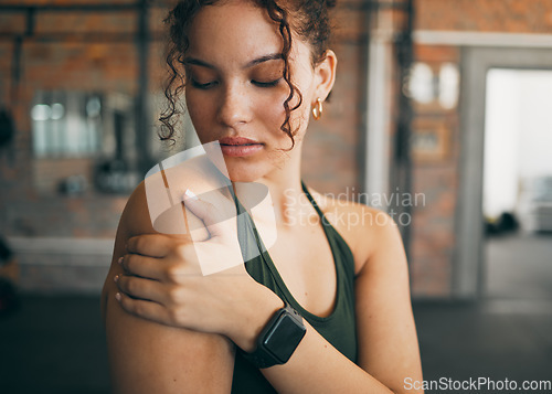 Image of Woman, shoulder pain and muscle injury from sports workout, exercise or training at the gym indoors. Female holding arm after painful sport accident, inflammation or bruise from intense exercising