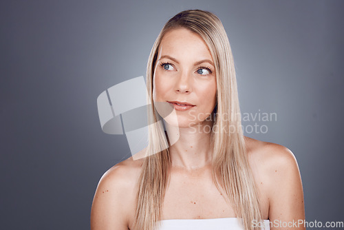 Image of Hair, beauty and thinking with a model woman in studio on a gray background for a haircare treatment idea. Wellness, health and keratin with an attractive young female posing to promote natural care