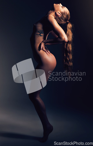 Image of Sensual, slim and woman model posing in studio with a sexy, seductive and alluring pose. Desire, hot and natural female body posing with sensuality while isolated by dark black background with light.