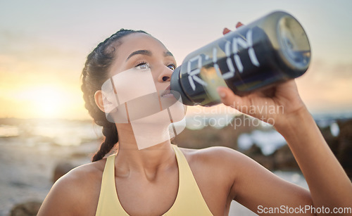 Image of Health, fitness and woman drinking water at beach after running, exercise or workout. Sports, hydration and thirsty female athlete with water bottle on break after training for wellness at sunset.