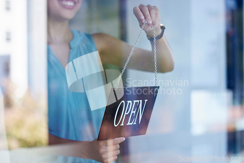 Image of Small business, woman and entrepreneur with open sign excited at professional shop window entrance. Smile of proud and happy business owner holding sign for store opening with enthusiasm.