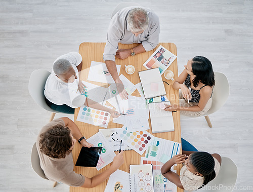 Image of Team work, hands or creative business people in a meeting planning a logo, branding or marketing color on paper. Designers, top view or employees working with senior manager on strategy or kpi goals