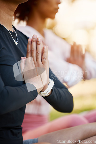 Image of Women, namaste hands and yoga meditation at park, wellness and freedom of chakra energy, zen fitness or peace. Closeup of calm friends, relax exercise and meditate in nature for mental health balance