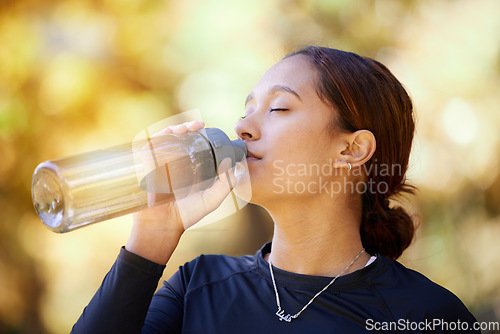 Image of Fitness, nature and woman drinking water after running for hydration, refresh and thirst. Sports, runner and female athlete enjoying a drink after cardio training for a race, marathon or competition.