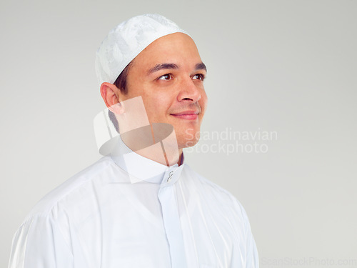 Image of Islam, culture and portrait of muslim man with smile on face in ramadan isolated on grey background. Youth, spiritual wellness and religion, happy Islamic scholar in white from Saudi Arabia in studio