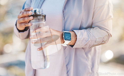 Image of Water bottle, runner hands and outdoor fitness for training workout hydration, exercise rest and sports wellness. Athlete, running break and drinking water for morning cardio routine in nature park
