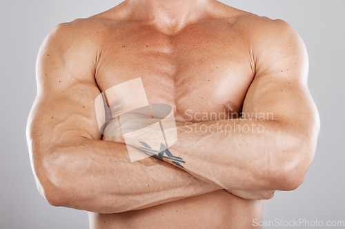 Image of Muscles, man and arms crossed with healthy lifestyle, diet and bodybuilding on grey studio background. Luxury, male bodybuilder or athlete with fitness, chest or body care for power, energy or strong