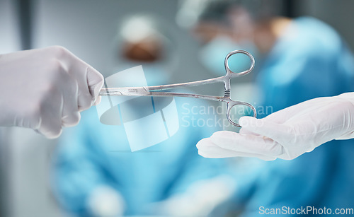 Image of Hospital, surgery and doctor giving scissors in hands for theatre teamwork, medical trust and support with healthcare insurance background. Metal tools, surgeon and nurse helping in an operating room