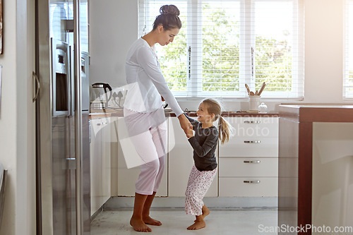 Image of Kitchen dancing, mother and daughter in the morning at home with happiness dancing together. Mom, girl and parent care holding hands with a young kid in a house happy about family with a smile