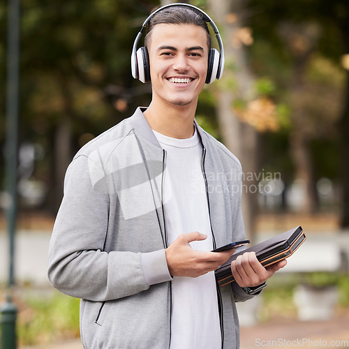 Image of Smartphone, headphones and student portrait in park for study at university, college or campus scholarship, knowledge and learning. Happy man with music technology with books for exam, test or school