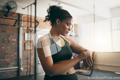 Image of Fitness, smartwatch and gym workout progess of a woman doing exercise, training and body wellness. Young sports female or athlete with app for time while active to be strong, healthy and for energy