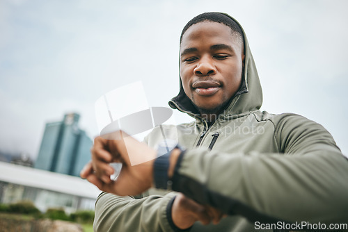 Image of Time, watch and black man running in city for fitness motivation, training goal and heart performance in Nigeria. Monitor, exercise and African runner with a smart watch for reading health progress