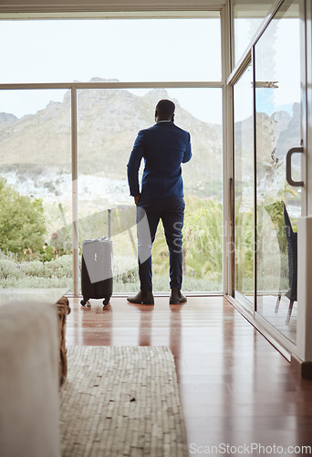 Image of Phone call, travel and businessman with a phone at a hotel for communication, connection and networking. Contact, talking and back of a black man in conversation on a mobile with luggage on a trip