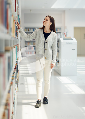 Image of Woman, student and search in library for book choice, knowledge or learning at bookstore for education. Female looking at bookshelf in study for decision, thinking or choosing thesis for scholarship