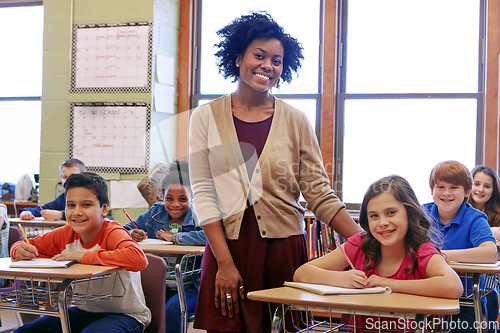 Image of Education, learning and teacher in classroom with kids writing exam or test at Montessori school. Portrait of black woman, happy children at desk and monitoring growth and development for school kids