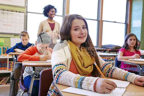 Image of Portrait, girl in classroom and writing with smile, learning and education for knowledge, focus and book. Teacher, female student and school for studying, development and thinking for test and exam