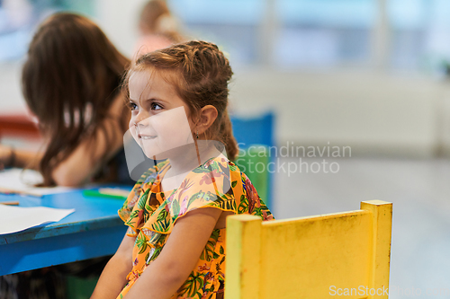 Image of Creative kids sitting in a preschool institution, draw and have fun while they get an education