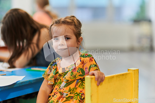 Image of Creative kids sitting in a preschool institution, draw and have fun while they get an education