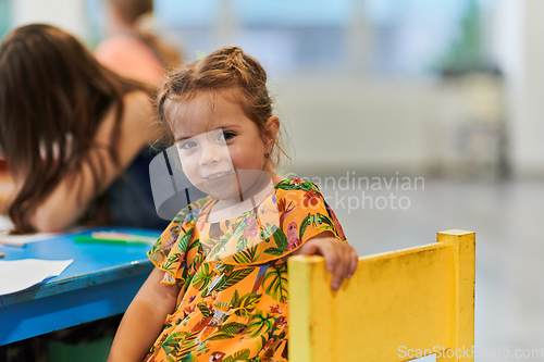 Image of Creative kids sitting in a preschool institution, draw and have fun while they get an education