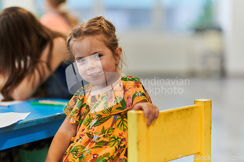 Image of Creative kids sitting in a preschool institution, draw and have fun while they get an education