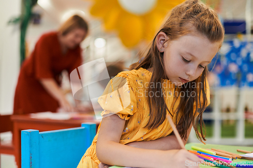 Image of Creative kids sitting in a preschool institution, draw and have fun while they get an education