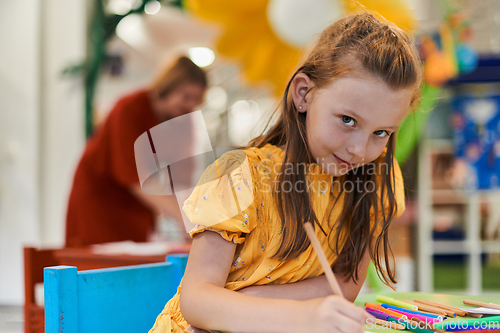 Image of Creative kids sitting in a preschool institution, draw and have fun while they get an education