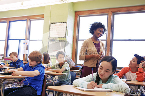 Image of Children, education or kids in classroom writing in notebook for learning, research or study for exam with teacher. Scholarship, thinking or students in school for test, academy or assessment