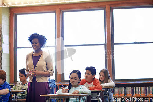 Image of Learning, education and students with teacher in classroom or primary school. Scholarship, development and children with books writing test, exam and studying with happy black woman and educator.