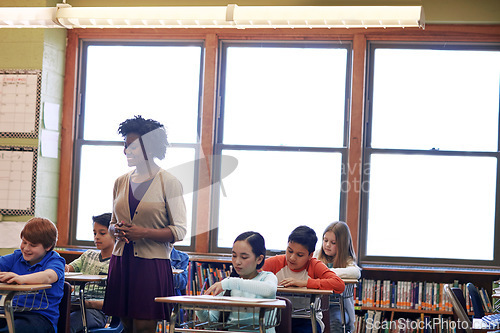 Image of School, teacher and children in student classroom for education, knowledge and development. Black woman in class to teach diversity kids or students together for learning, studying and writing test