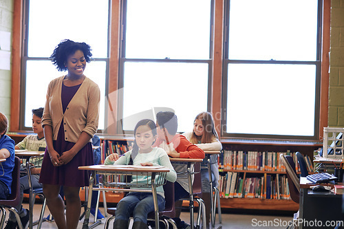 Image of Education, learning and students with teacher in classroom or primary school. Scholarship, development and children with books writing and studying with happy black woman and educator checking work.