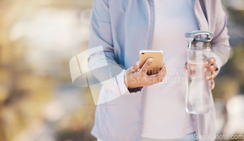 Image of Running, water and phone with hands of woman in mountain for jogging, workout or cardio training. Social media, progress tracker or fitness app with runner on path checking mobile for endurance goals