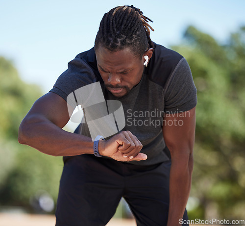 Image of Fitness, black man and smart watch time for running exercise, workout challenge or healthy marathon training. Stopwatch, sports runner and athlete break to monitor steps count, heart rate or progress