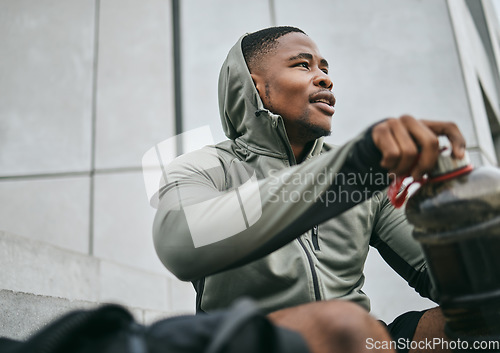 Image of Fitness, gym or black man drinking water after training, exercise or workout for healthy body hydration. Relaxing, mindset or tired sports athlete with goals, motivation or mission resting in Chicago