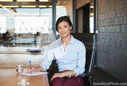 Image of Business woman, portrait smile and writing for planning, strategy or signing contract of employment at office desk. Young female employee working on paperwork for corporate plan or idea at workplace