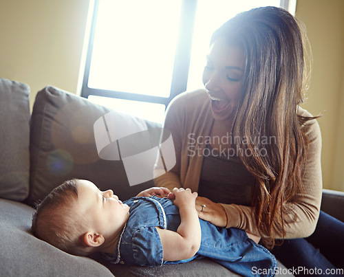 Image of Mom, bonding or laughing baby girl in house living room or family home sofa in goofy, comic or funny tickle game. Smile, infant and happy mother playing with child after changing diapers on furniture