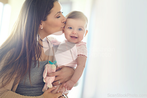 Image of Mother, bonding and forehead kiss for baby girl on in house living room, nursery or family home bedroom in trust or love. Smile, happy and infant child with mom in support, security or safety comfort