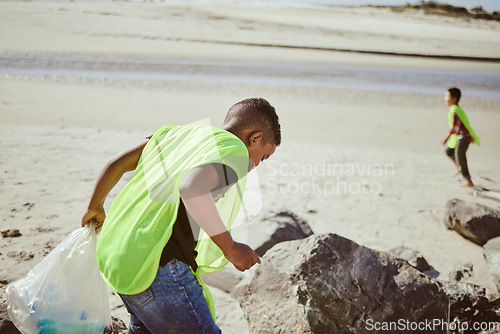 Image of Environment, cleaning and children with plastic on beach for clean up, pollution and eco friendly volunteer. Sustainability, recycle and boy reduce waste, trash and global warming on beach sand