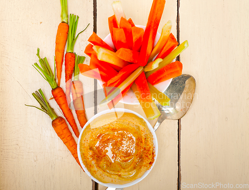 Image of fresh hummus dip with raw carrot and celery