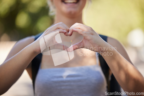 Image of Hands, woman and heart emoji in nature while outdoor for love, freedom and support for summer travel adventure. Happy young female with hand sign and backpack for motivation, peace and wellness