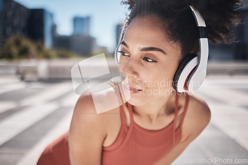 Image of Fitness, headphones and tired black woman runner stop to relax or breathe on city run or workout. Health, urban training and wellness, woman on break from running exercise while streaming music app.