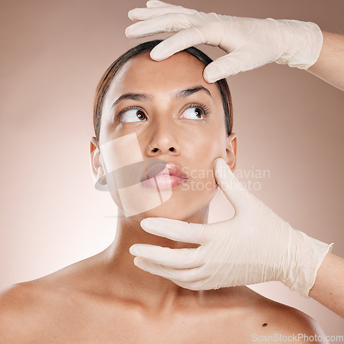Image of Plastic surgery, botox and hands check woman face for laser, beauty implant or cosmetic salon. Skincare consultation, facial and gloves for aesthetic change at liposuction clinic on studio background