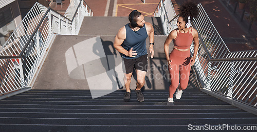 Image of Fitness, stairs and city with a diversity couple training for sports, cardio or endurance outdoor together. Workout, health and exercise with a man and woman athlete running up a staircase from above