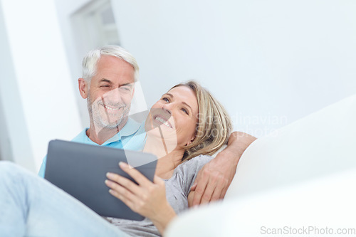 Image of Senior, tablet and couple on a house couch on technology laughing and watching a movie on tech, Home, sofa and mature people in love with care smile about internet meme or social media scroll