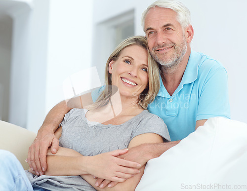 Image of Senior couple, portrait and love in their home while happy about retirement, love and support. Commitment of a man and woman in a healthy marriage with trust, care and security on a living room couch