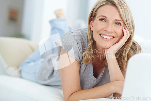 Image of Portrait of mature woman lying on sofa in living room, happiness and relaxing in comfort at home. Smile, lazy weekend time and happy woman in peace chilling on comfortable couch in apartment on break